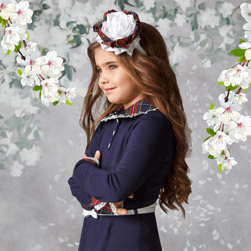 Платье отрезное по линии талии, юбка – полусолнце состоящей из двух частей. Нижняя часть юбки из отделочной ткани, верхняя из основной. Перед платья с рельефами от проймы до талии. Застежка на три прорезные петли и пуговицы от горловины на планке. Рукав длинный, втачной, заканчивается притачными манжетами из отделочной ткани. Манжеты из отделочной ткани застегиваются на прорезную петлю и пуговицу. Воротник отложной, выполнен из отделочной ткани. Основная ткань на платье – трикотаж. Отделка из ткани полушерсть – клетка. По низу юбки, манжета, воротника втачены белые кружева. По линии талии продернут в петли декоративный ремешок.  Состав ткани: 70% вискоза, 20% полиэстер, 10% эластан, Тип товара: Платье, Коллекция: синий с васильковой клеткой, Класс в школе: 1-4 класс,